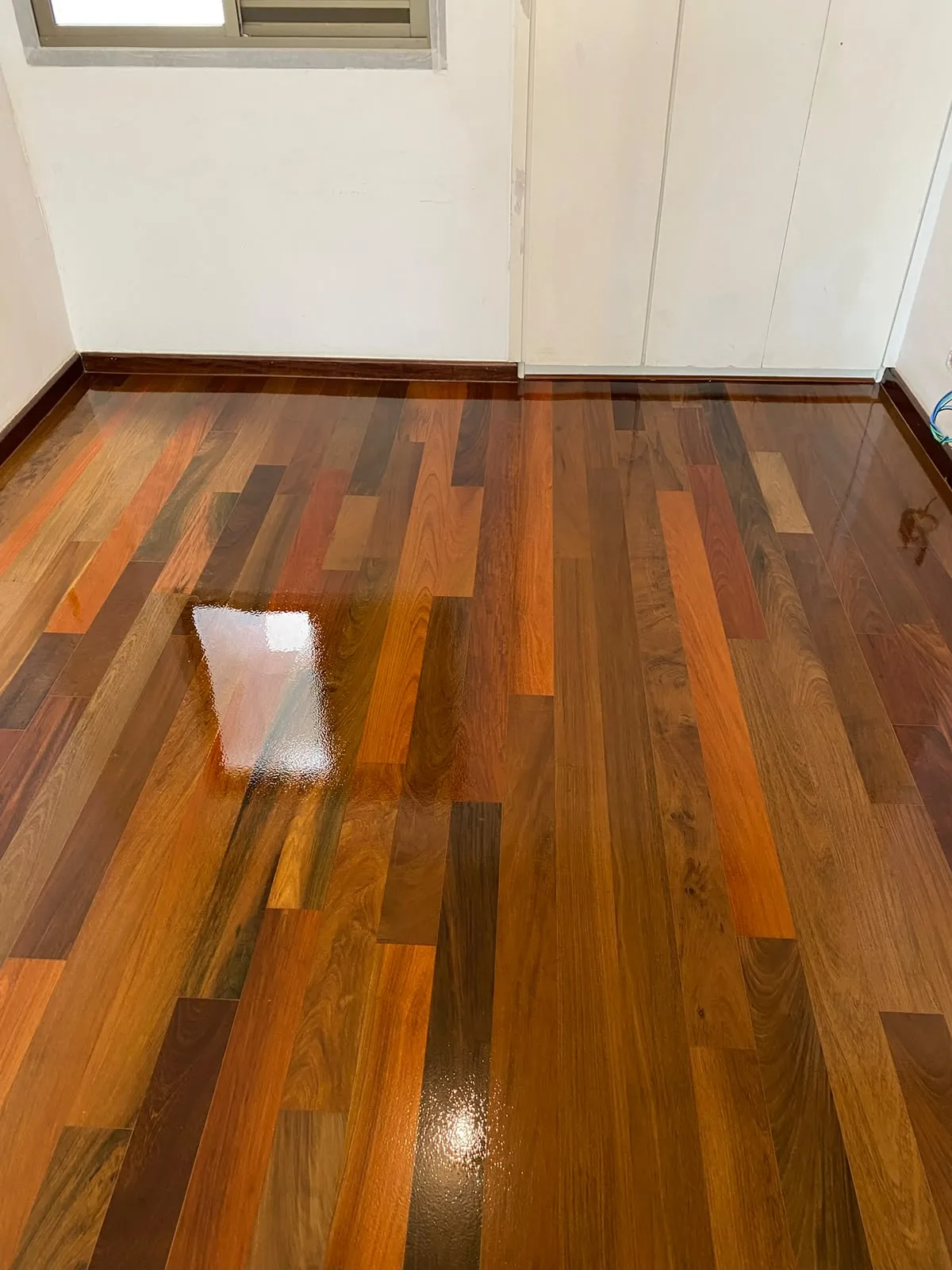 Assoalho de Ipê com réguas de tons variados e acabamento brilhante